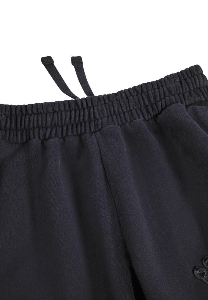 Close-up of black pants with an elastic waistband on a white background