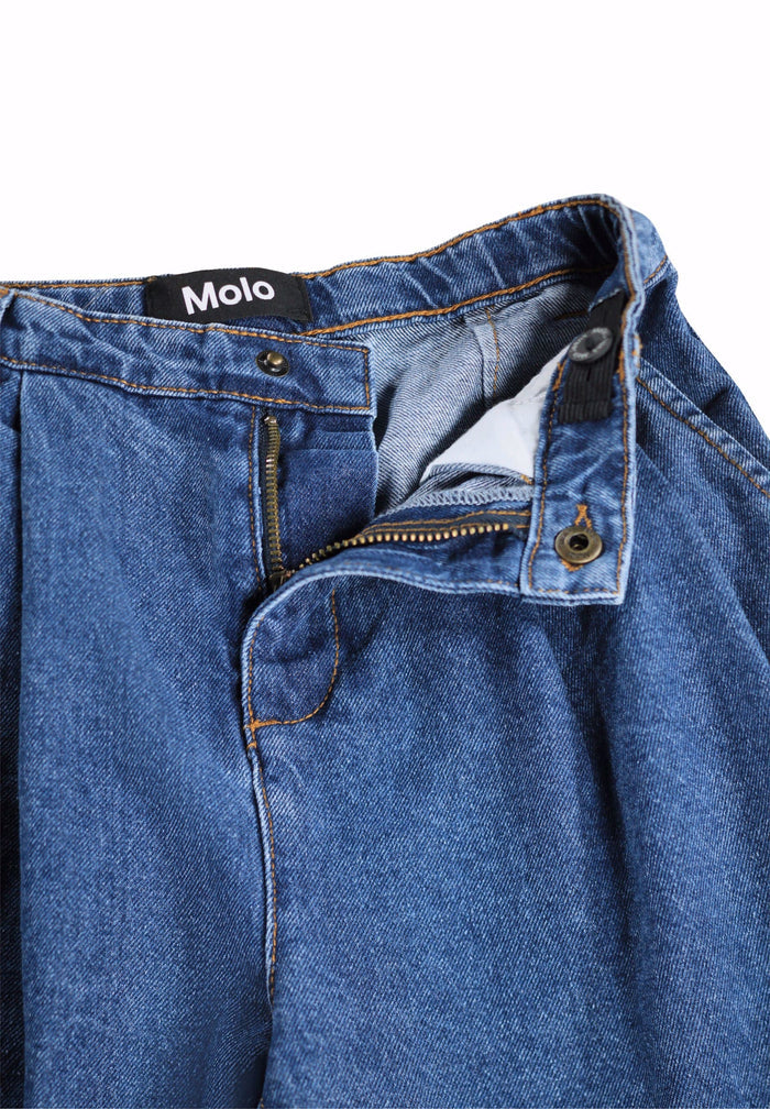 Close-up of blue jeans with a Molo label on a white background