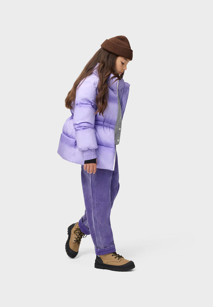 Person wearing a purple puffer jacket and pants on a white background