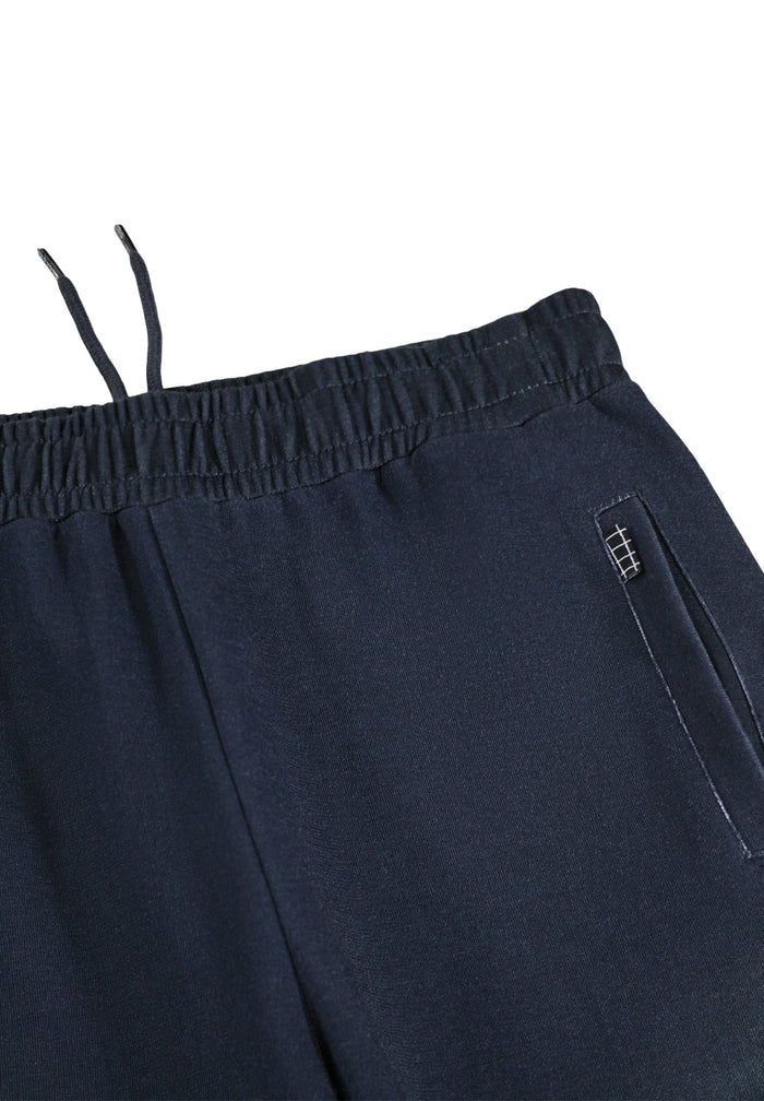 Close-up of dark blue pants with a pocket on a white background