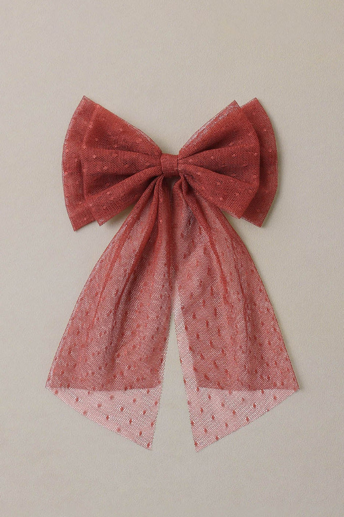 Ruby bow with lace details on a beige background