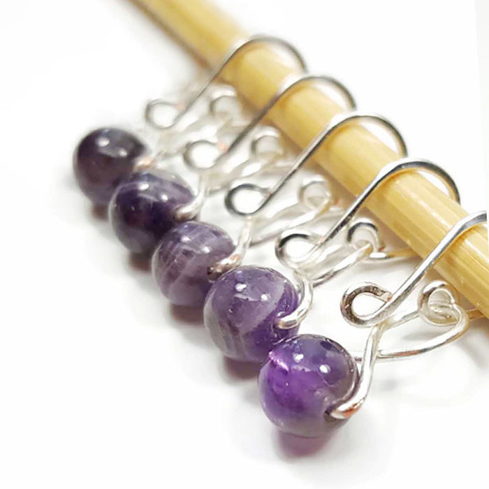 Five amethyst bead melody ring removable stitch markers with silver hooks on bamboo knitting needle
