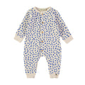 A baby long-sleeve footless romper in cream cotton with a blue spotted pattern, featuring a snap-button front and ribbed cuffs and hem.