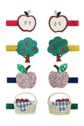 Six colorful fabric hair clips featuring apple and basket motifs, arranged in two columns on a plain white background.