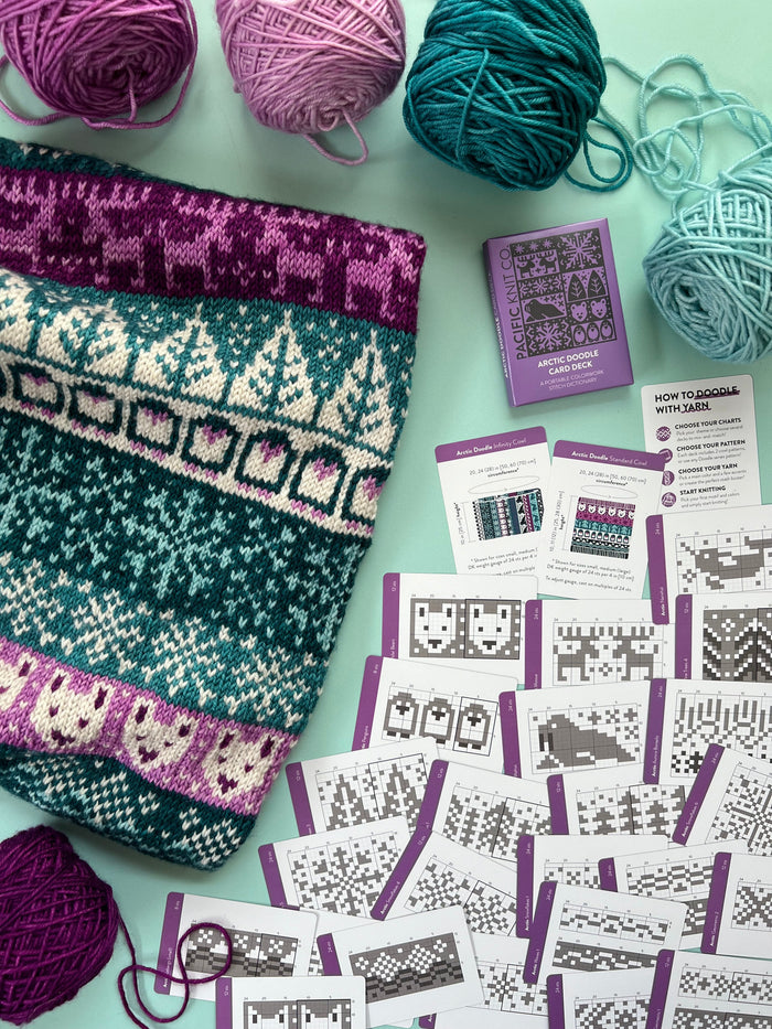 Arctic Doodle chart cards beside a teal and purple polar colorwork knit