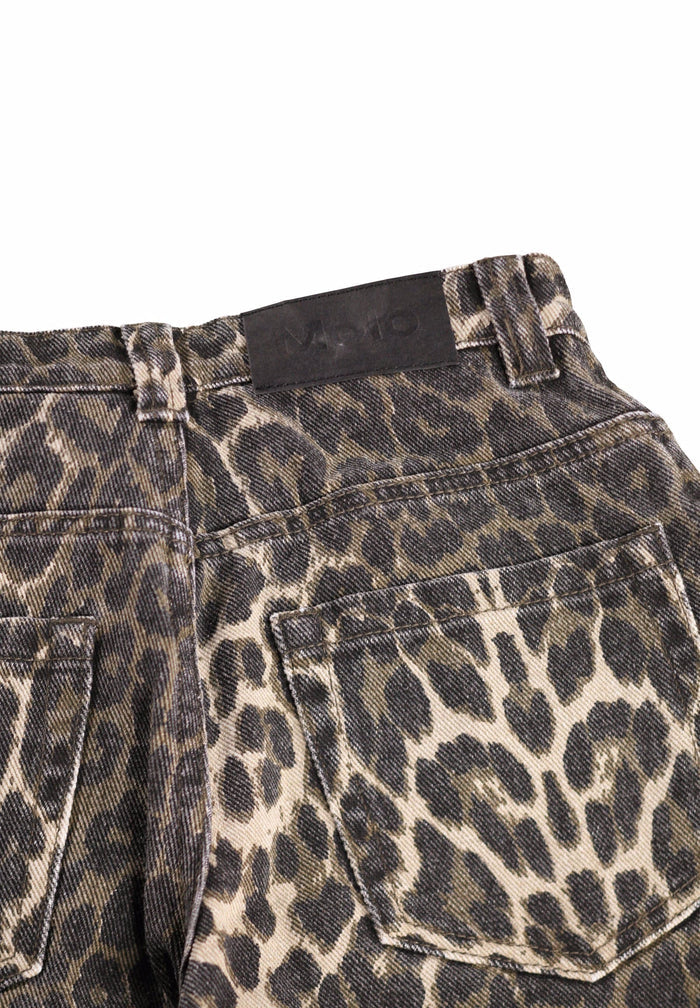 Close-up of leopard print pants with a brand label on a white background