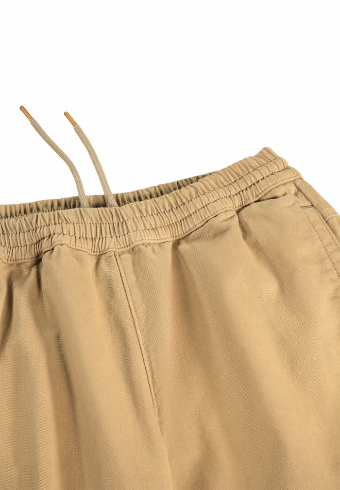 Close-up of beige pants with an elastic waistband on a white background
