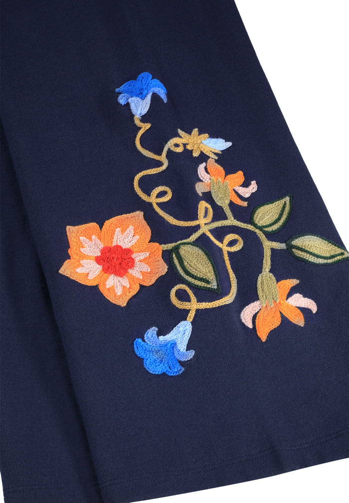 Embroidered floral design on a dark fabric background