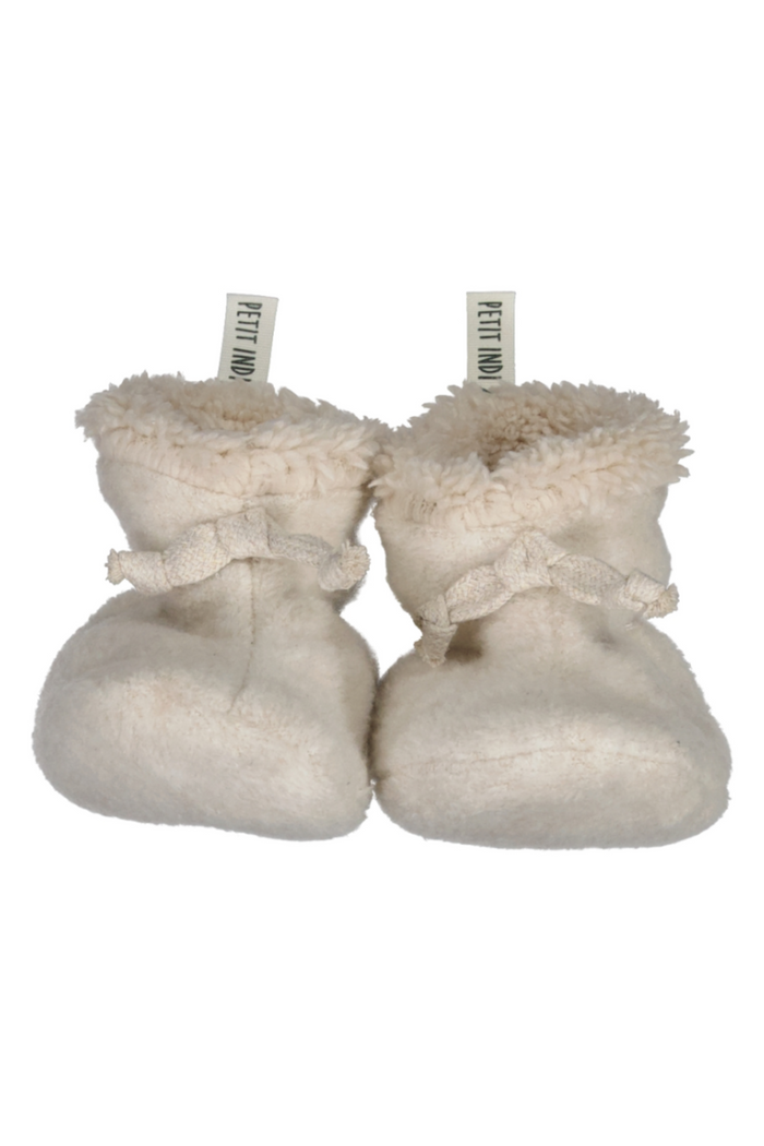 Pair of cream baby booties with fluffy texture on a white background