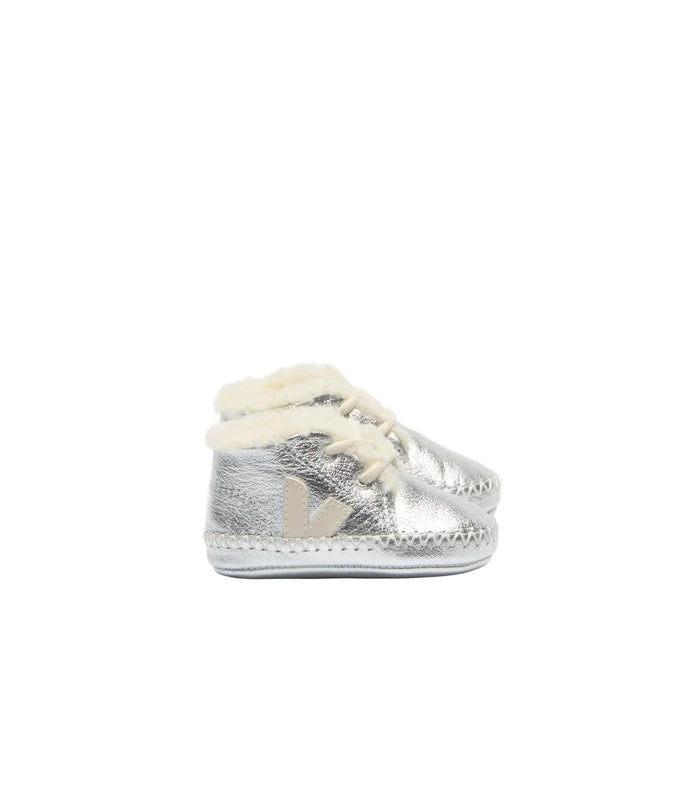 A pair of metallic silver baby booties with cream-colored faux fur lining and a small beige decorative accent on the side, set against a plain white background.