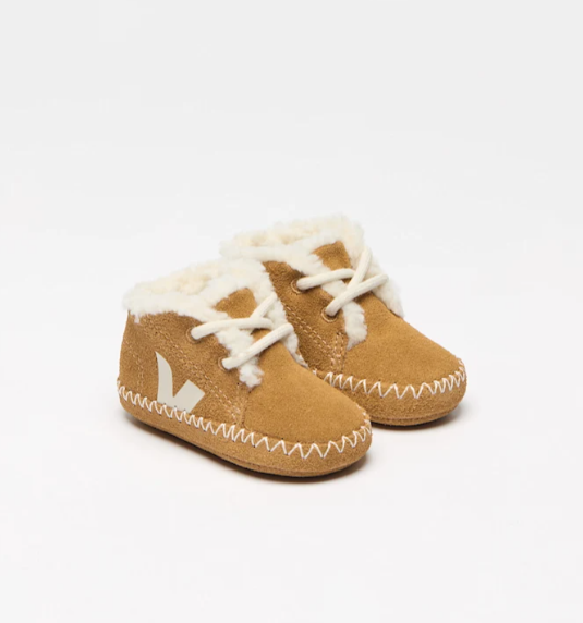 Pair of tan baby boots with white fur lining on a white background