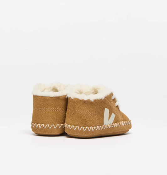 Pair of brown baby boots with white fur lining on a light gray background