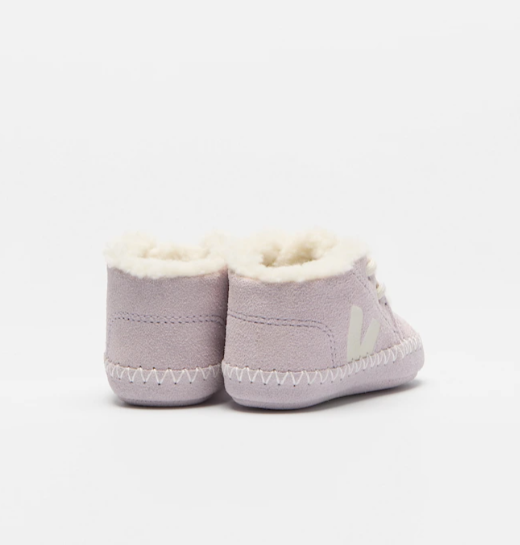 Pair of purple baby booties with white fur lining on a light gray background