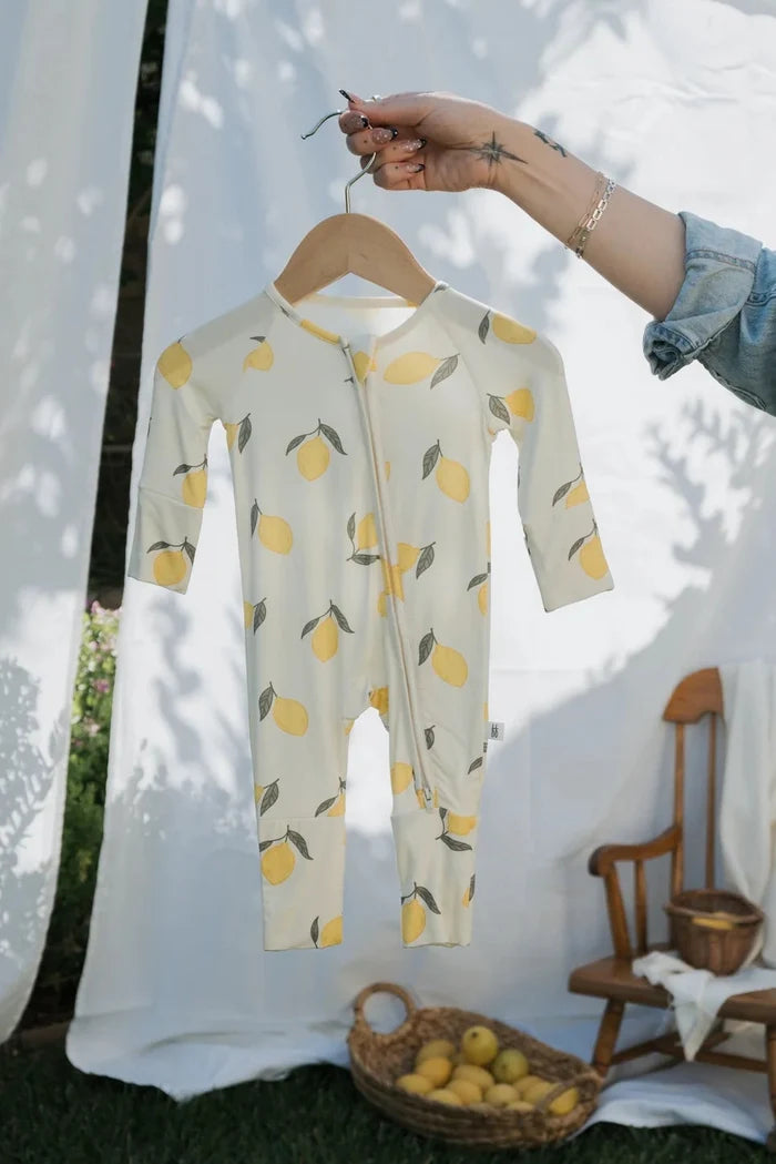 Baby onesie with lemon pattern on a hanger outdoors