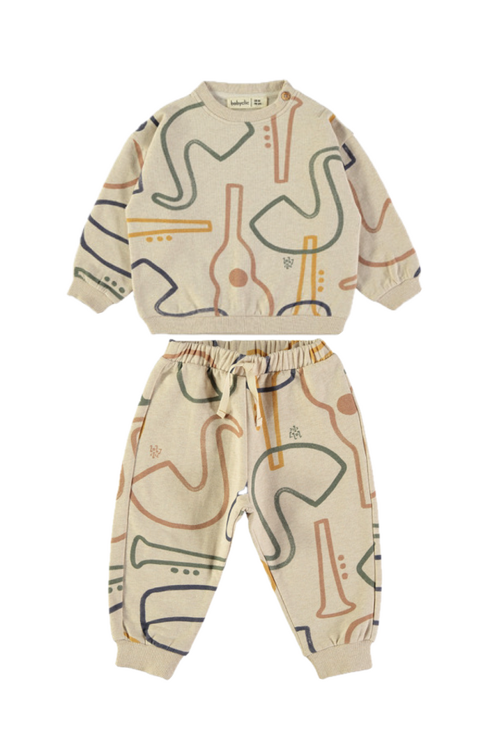 cream sweatset with instrument graphics throughout. matching sweatshirt and sweatpants on white background