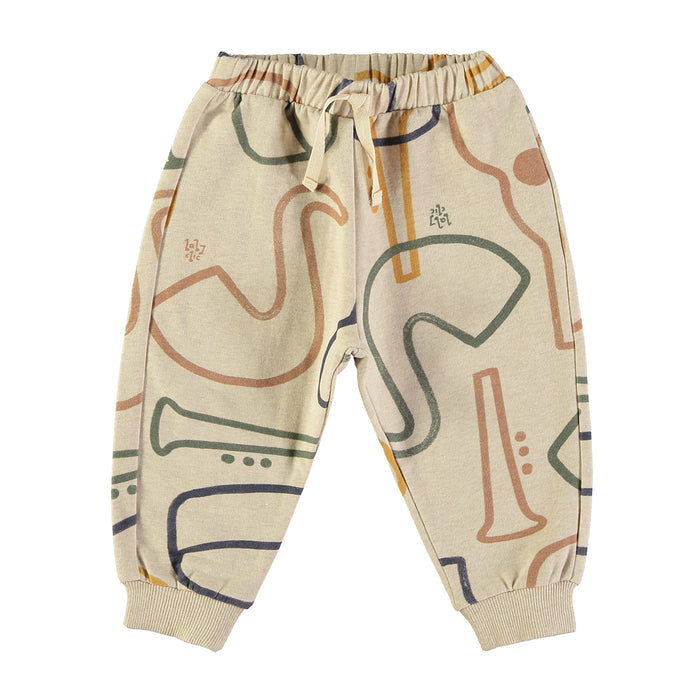 A pair of children's jogger sweatpants in beige with an abstract line art pattern of musical instruments in muted green, orange, and navy blue, shown against a plain white background.