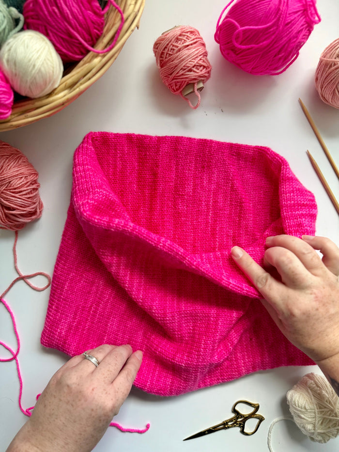 Hands adjusting a hot pink Base Doodle Infinity Cowl