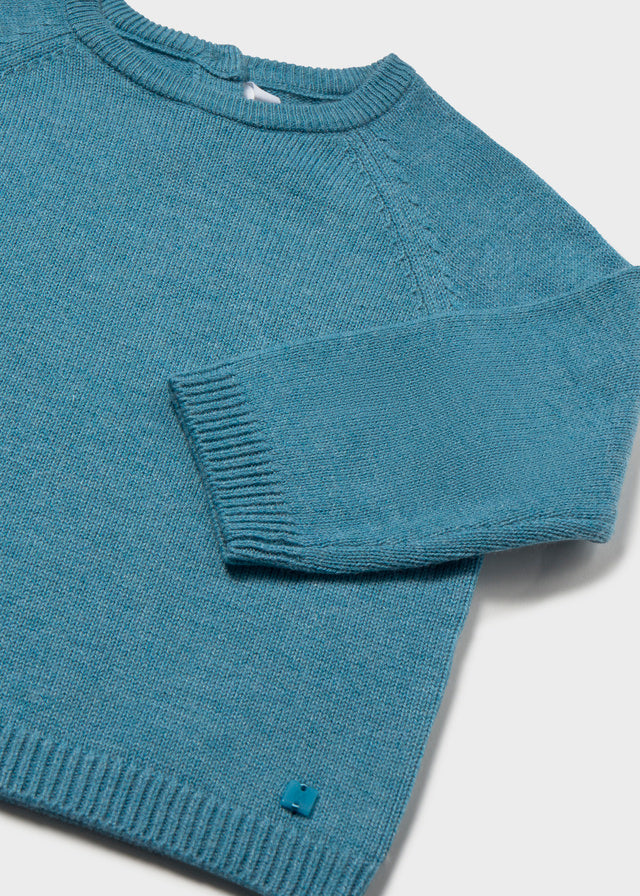 Blue knitted sweater on a light gray background