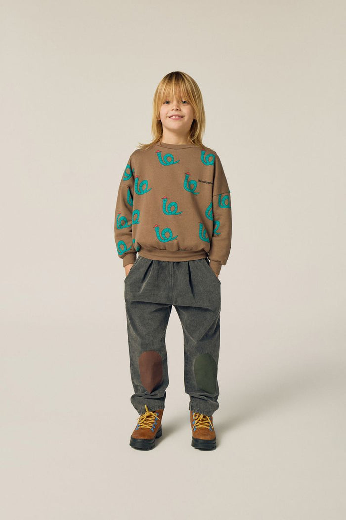 Child wearing snakes sweatshirt and bicolor denim trousers