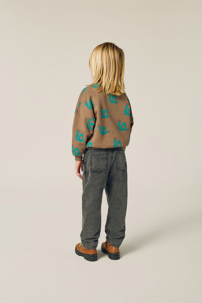 Child wearing snakes sweatshirt and bicolor denim trousers