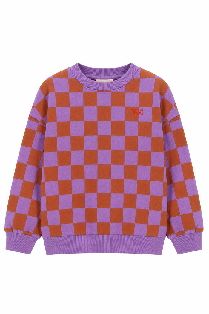 A purple and rust-orange checkered crewneck sweatshirt with a small red embroidered logo on the left chest, displayed on a solid white background.