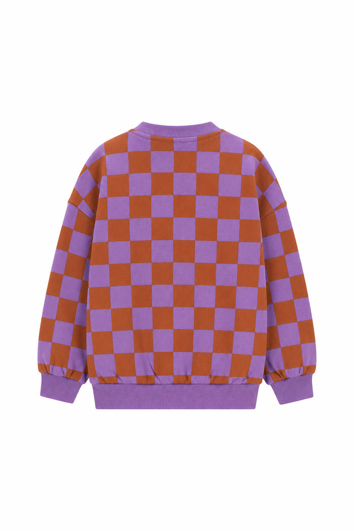 A long-sleeve crewneck sweatshirt featuring a purple and rust-orange checkerboard pattern, with solid purple ribbed cuffs, hem, and collar, shown against a plain white background.