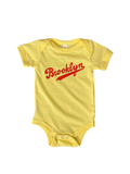 yellow baby onesie with red Brooklyn baseball font logo