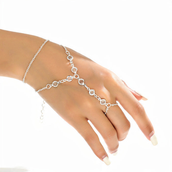 Silver Y shaped hand chain bracelet with ring worn on woman’s hand with white manicure, delicate crystal slave bracelet showing how it drapes from wrist to finger