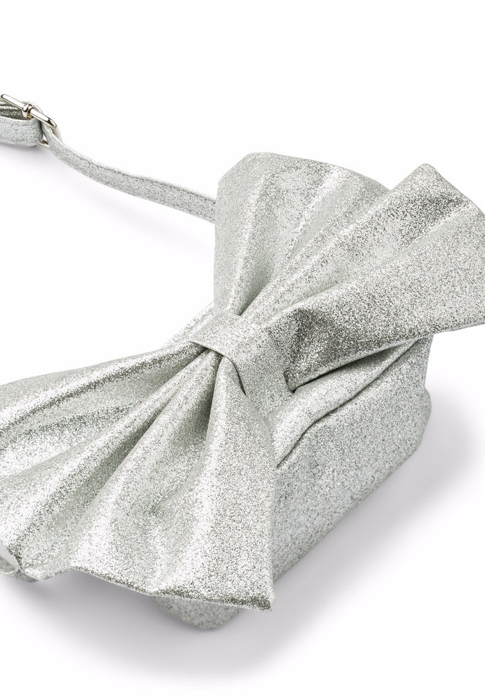 Silver glittery handbag with a large bow on a white background