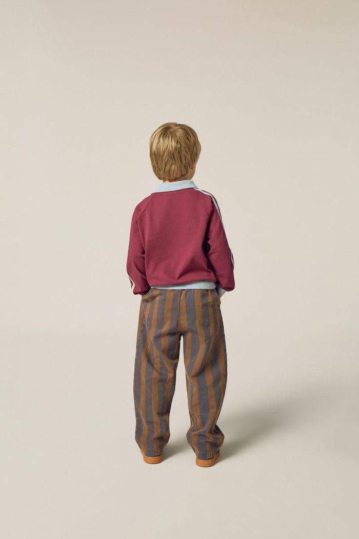 child wearing burgundy polo and stripes trousers