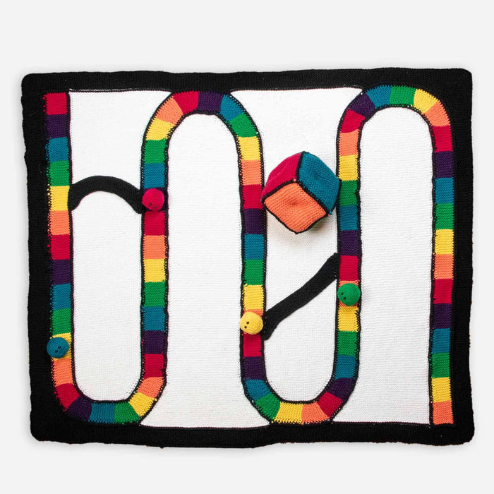 Full knitted Candyland game board with winding rainbow-colored path on white background with black border, knitted gumdrop game pieces and multicolored die placed on the board