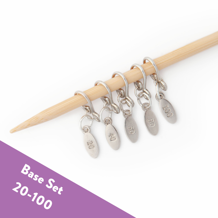 Base Set of five silver stitch markers numbered 20 through 100 on a bamboo knitting needle