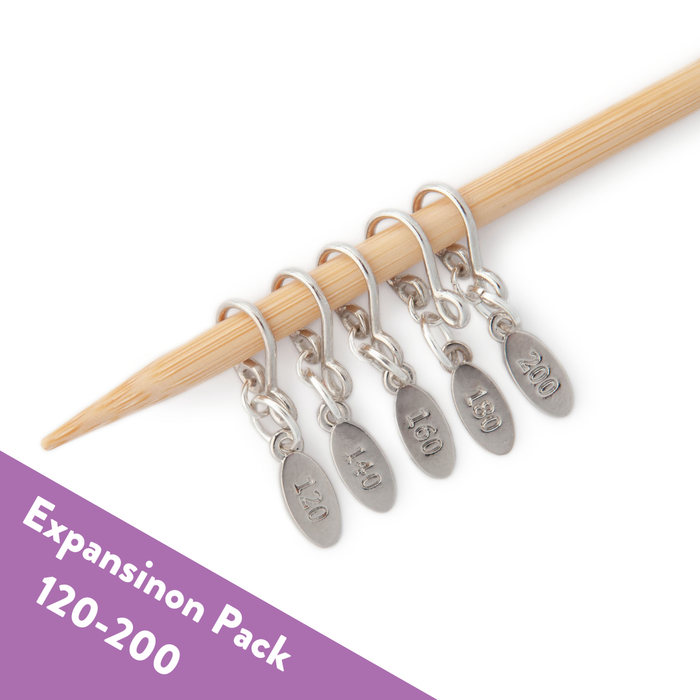 Expansion Pack of five silver stitch markers numbered 120, 140, 160, 180, and 200 on a bamboo knitting needle