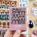 Hand holding the pink Cat Doodle Card Deck by Pacific Knit Co tuckbox