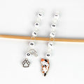 Cat Lovers Odd and Even row counter set — two chain counters hanging side by side on a bamboo knitting needle, the even chain (left) with numbered beads 0, 2, 4, 6, 8 ending in a silver paw print charm, and the odd chain (right) with beads 1, 3, 5, 7, 9 ending in an enamel calico cat charm