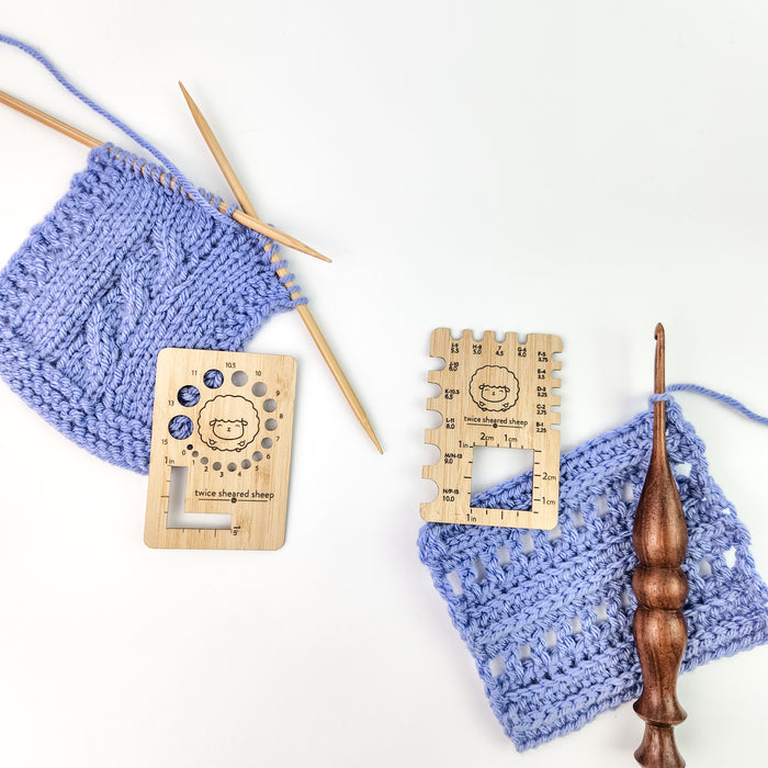 Twice Sheared Sheep wooden gauge tools shown with blue cable knitting swatch and blue crochet swatch with wooden hook