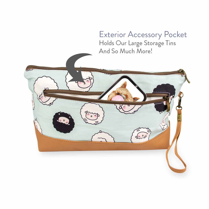 Back view of the Chubby Sheep Trinity Bag with a phone and storage tin tucked into the exterior accessory pocket, with text overlay reading Exterior Accessory Pocket — Holds Our Large Storage Tins And So Much More