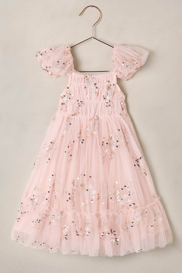 Pink  dress on a hanger against a beige background