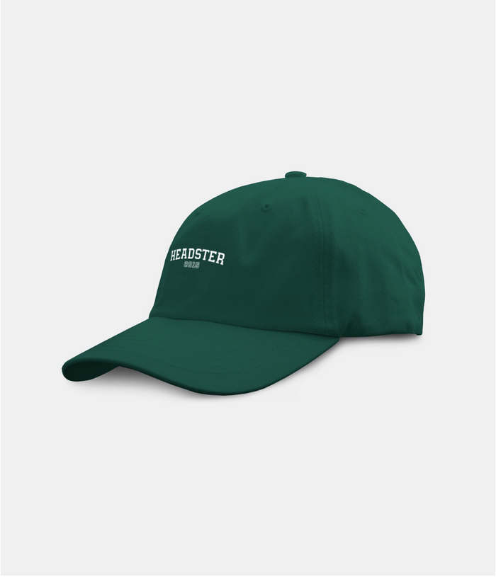 A dark green baseball cap with 'HEADSTER' and 'EST. 2015' embroidered in white on the front, shown against a light gray background.