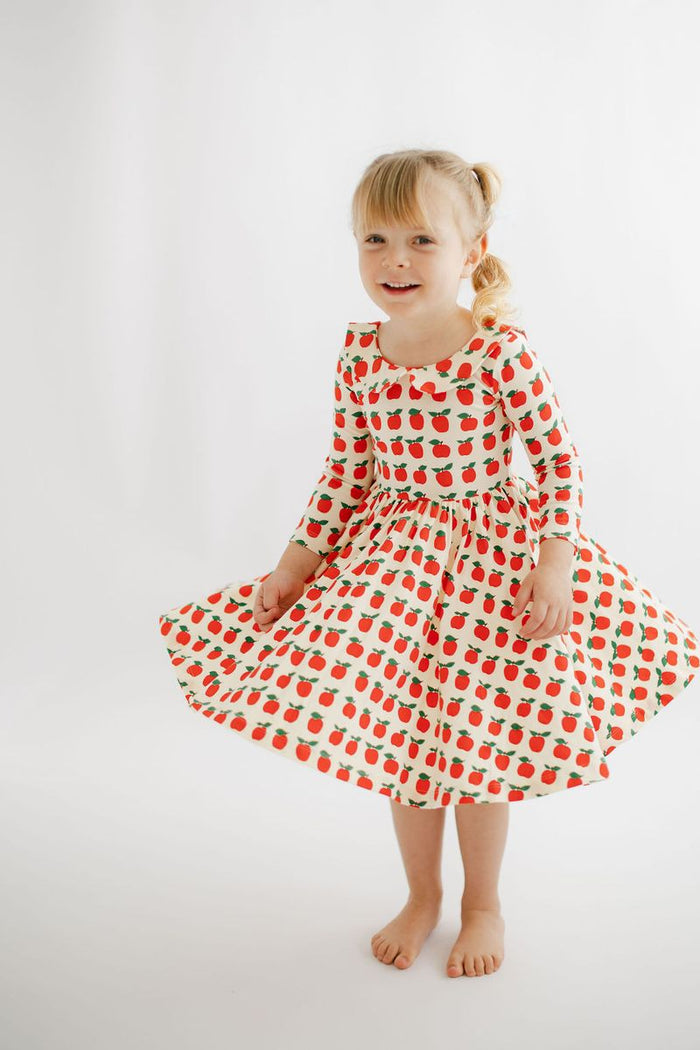 Young girl wearing a red and white checkered dress on a white background