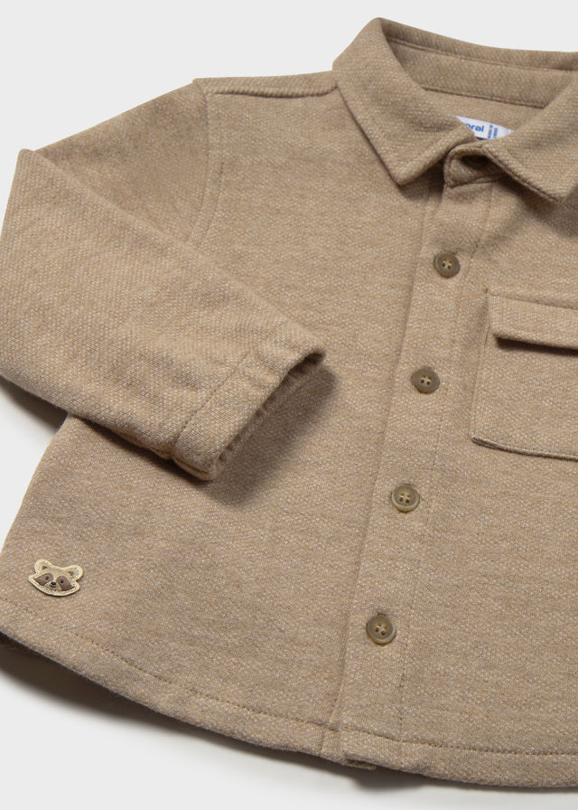 Close-up of a brown button-up shirt with a collar on a white background