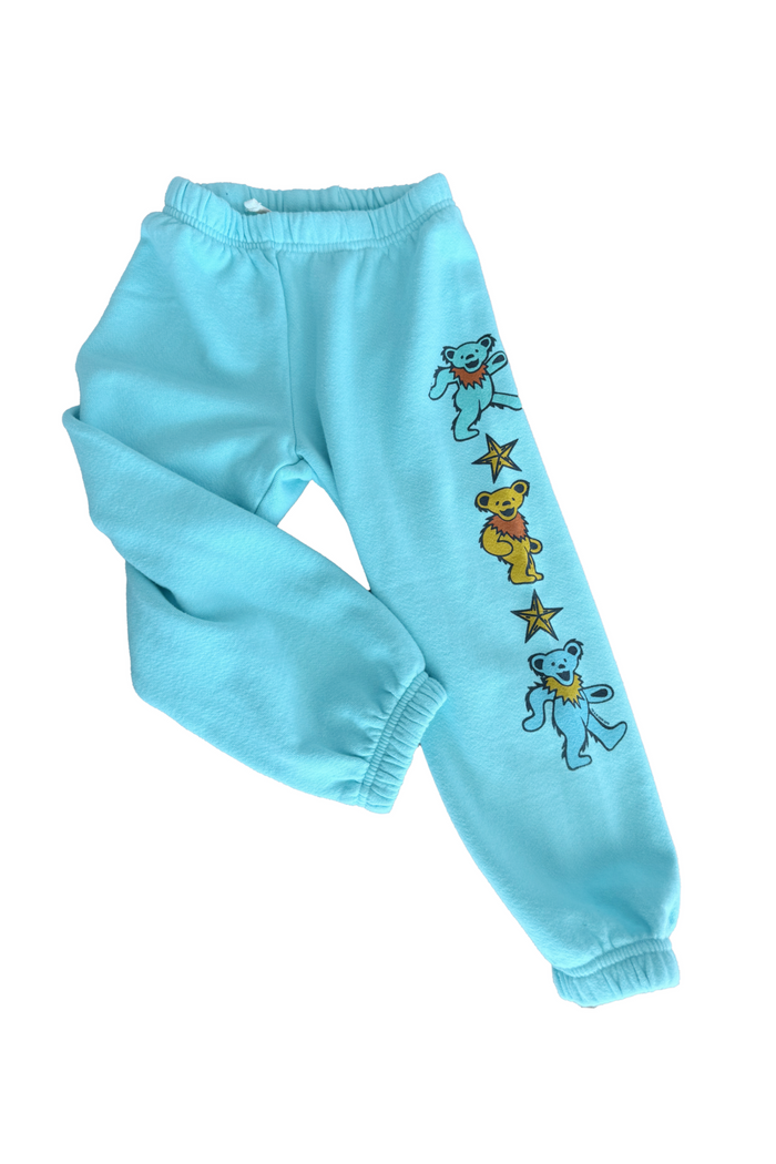 Light blue sweatpants with bear and star designs on a white background