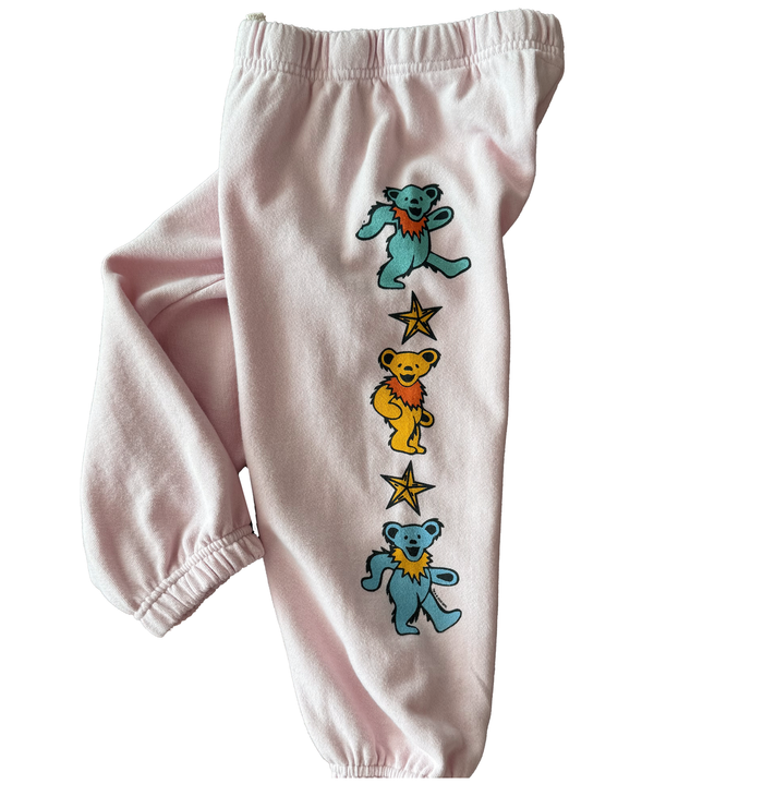 Pink sweatpants with bear and star designs on a white background