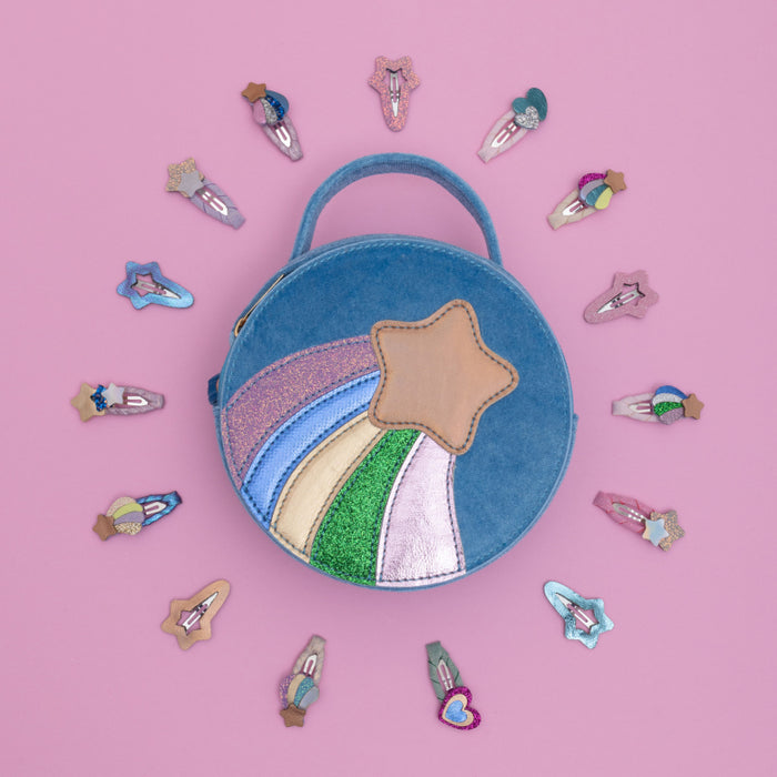 A light blue circular crossbody bag with a rainbow and star design on the front, featuring a top handle and an adjustable shoulder strap, set against a plain white background.