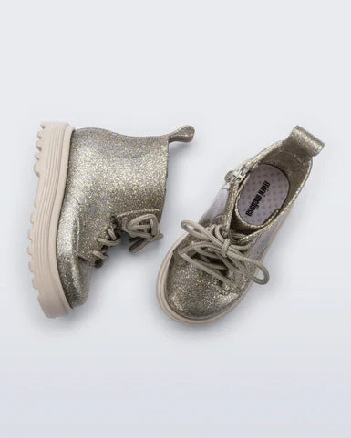 Pair of glittery gold boots on a white background