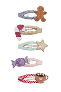 A set of five children's hair clips with holiday and candy-themed designs, including gingerbread, candy canes, a star, a wrapped candy, and a hot cocoa mug, shown on a plain white background.