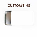 Custom Tins title graphic showing a large sliding-lid metal storage tin partially open with a blank white customizable sticker on the lid