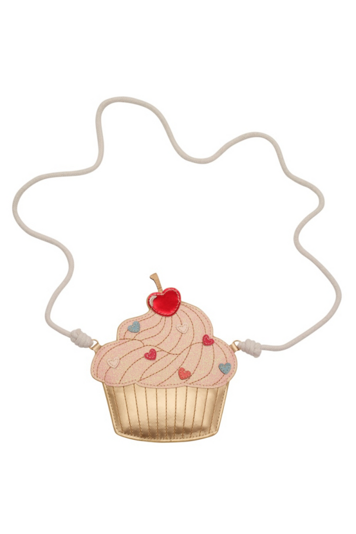 A cupcake shaped purse with pink frosting, a red cherry on top, and a gold-colored wrapper, suspended from a thin white cord on a plain white background.