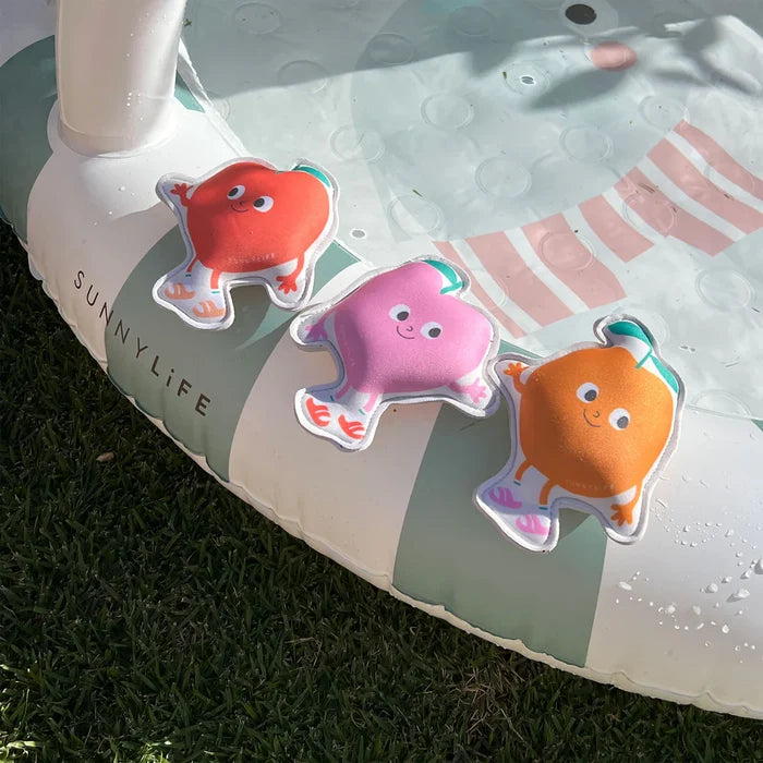 Three colorful dive toys on a Sunnylife inflatable pool toy.