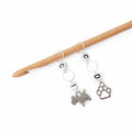 Dog and pawprint crochet increase decrease counter stitch markers with letter beads hanging from wooden crochet hook